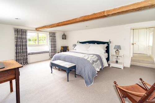 ein Schlafzimmer mit einem Bett, einem Stuhl und einem Tisch in der Unterkunft French Mill in Shaftesbury