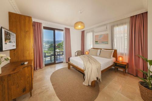a bedroom with a bed and a balcony at Kiraz Vela Selimiye in Marmaris