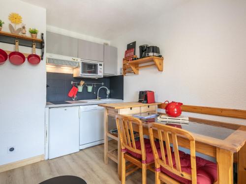 a small kitchen with a wooden table and chairs at Le Belvedere N11 - ST4 in Saint-Sorlin-dʼArves