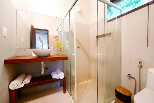 a bathroom with a glass shower and a sink at Licuri Praia de Algodões na beira do mar in Marau
