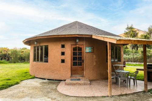 a small house with a patio and a table at Cabañas Refugio El Molle in El Molle