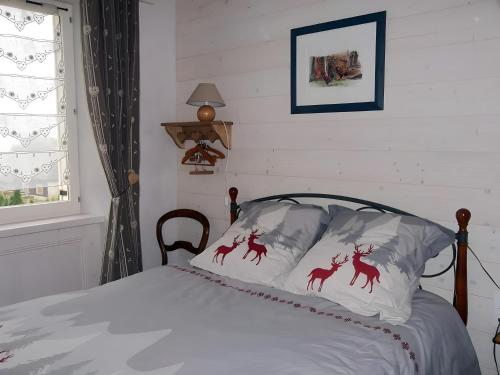 a bed with white sheets with deer on it at Gite Le Chant Du Coq in Bief-des-Maisons