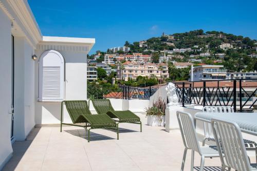 a balcony with chairs and a view of a city at Les Pins in Cannes