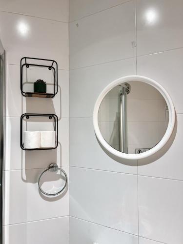 a bathroom with a mirror and a white wall at Malta Crown guesthouse in St. Julianʼs