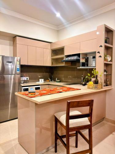 a kitchen with a counter with a chair and a refrigerator at Romantic Sky Studio with Pool by The Nook in Sohna