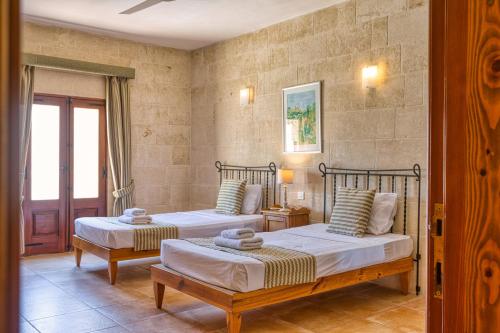 a bedroom with two beds and a window at Ta' Gianni in Xewkija