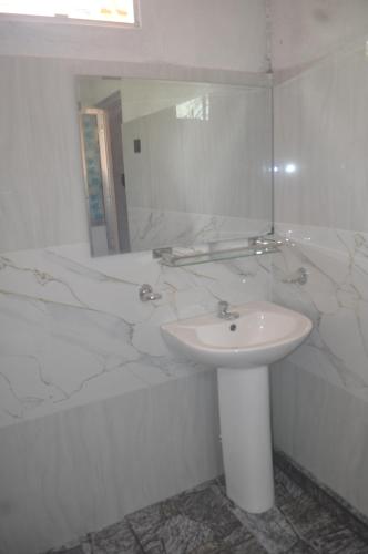a white bathroom with a sink and a mirror at Talalla Mango House in Talalla South