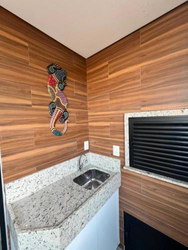 a kitchen with a counter with a sink and a window at Apê Ásia in Governador Celso Ramos
