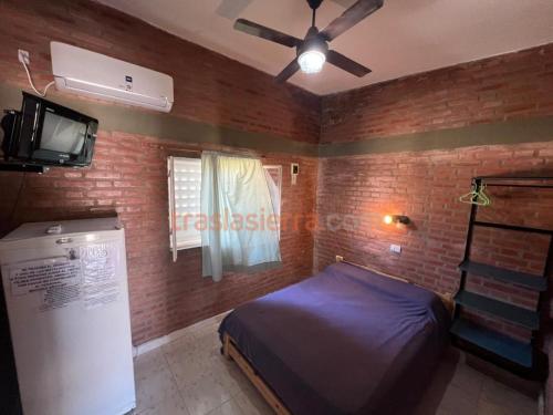 a bedroom with a bed and a ceiling fan at Mi Petaka in Villa Cura Brochero