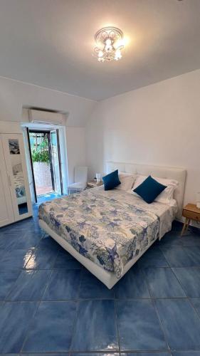 a bedroom with a bed with blue pillows on it at Casa Emi in Amalfi