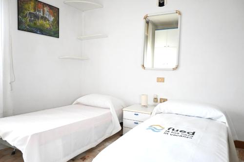 a room with two beds and a mirror at SE274 - Marotta, ampio quadrilocale con posto auto in Marotta