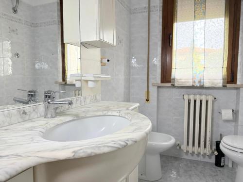 a white bathroom with a sink and a toilet at SE274 - Marotta, ampio quadrilocale con posto auto in Marotta