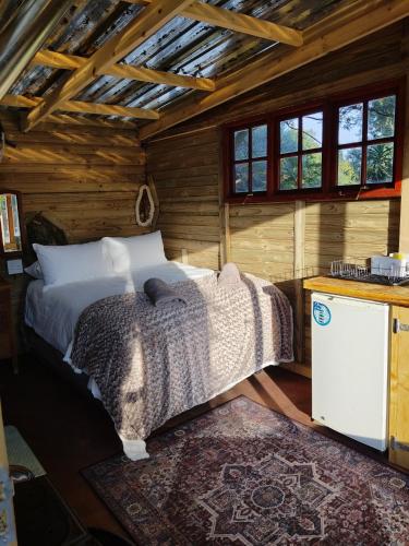 a bedroom with a bed in a log cabin at Tree house Living in Roodepoort
