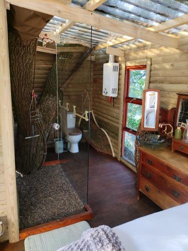 a bathroom in a log cabin with a toilet and a sink at Tree house Living in Roodepoort
