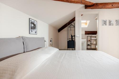 a white bedroom with a large white bed at Lake View - Gardone Center - Private Garage in Gardone Riviera