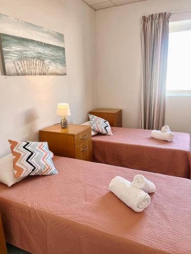 a hotel room with two beds with towels on them at Malta Crown guesthouse in St. Julianʼs