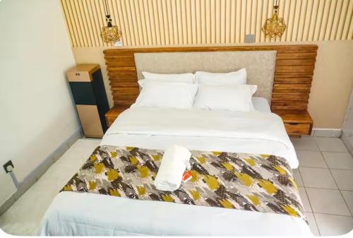 a bedroom with a large bed with white sheets at Omtush Suites 002 in Marimbeti