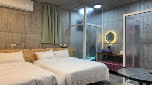 a bedroom with two beds and a table and a table at 騎馬打仗民宿 in Yilan City