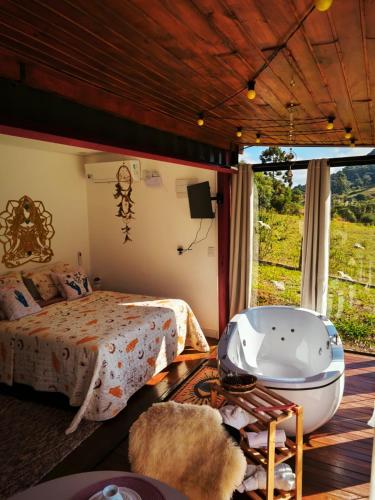 a bedroom with a bed and a bath tub at Chalés Recanto dos Sonhos in Camanducaia