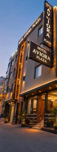 a hotel with a sign on the side of a building at Hotel Aviora Plaza By Almati Group Near IGI Delhi Airport With - Free Airport Pickup in New Delhi