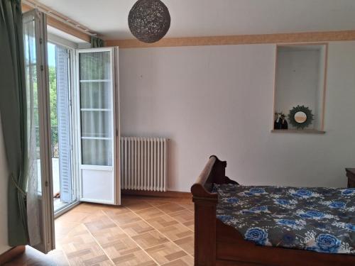 a bedroom with a bed and a glass door at Le Picasso in La Chaise-Dieu