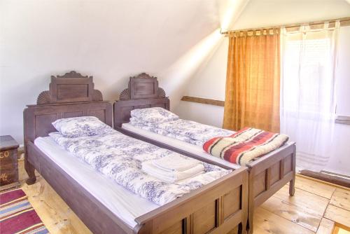 two twin beds in a room with a window at Dominic Boutique - Gardener's Cottage in Cloaşterf