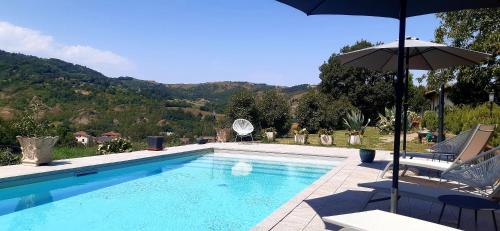 a swimming pool with an umbrella and two chairs and a table and an umbrella at Casa Stella Country House in Savigno