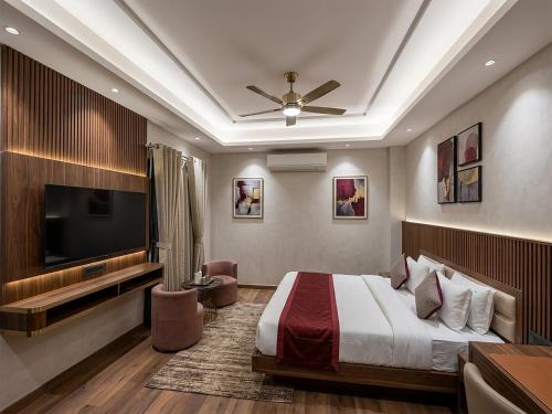 a hotel room with a bed and a flat screen tv at V Hotel Dev Residency Airport Pick up complimentary in New Delhi