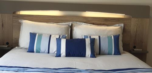 a bed with blue and white pillows on it at La terrasse des oiseaux in Taillet