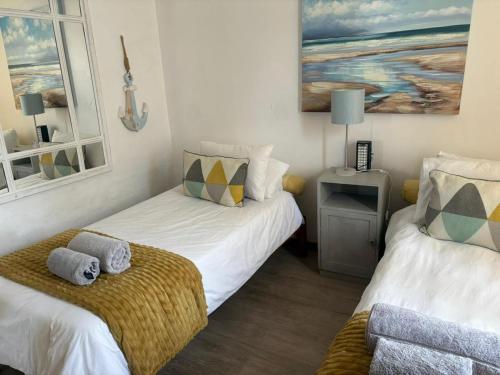 two beds in a room with two windows at Sundowner in Yzerfontein