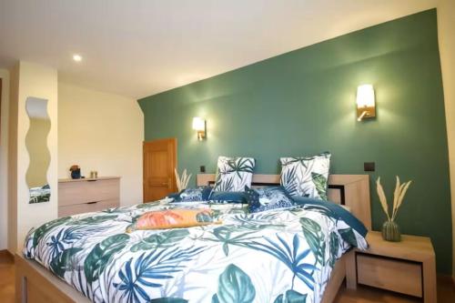 a bedroom with a bed with a green wall at Le Courlis du Ried in Grussenheim