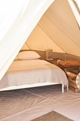 ein Schlafzimmer mit Bett in einem Zelt in der Unterkunft DE BUITENKANS urban camping - unique cabins in Rotterdam