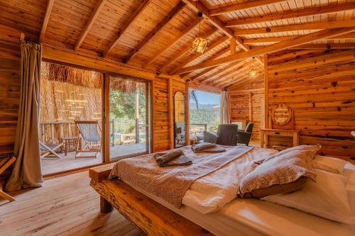 ein Schlafzimmer mit einem Bett in einer Blockhütte in der Unterkunft Flavia Hotel in Kızılcakaya