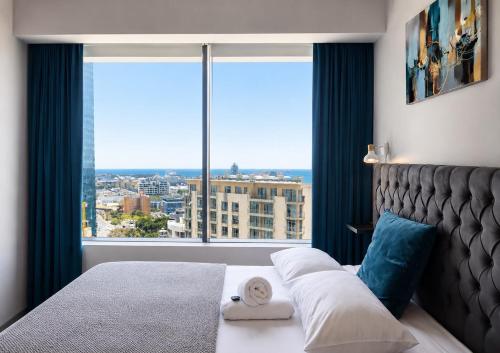 a bedroom with a bed with a large window at One Thibault Hotel - Sea View Studio - Near CTICC & V&A Waterfront in Cape Town