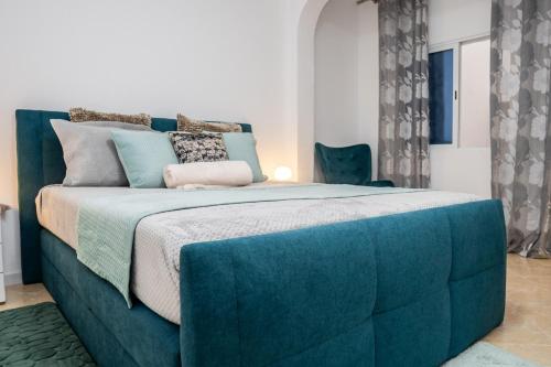 a bedroom with a large blue bed with pillows at Appartement Chanel in Assomada