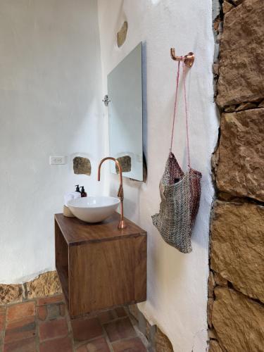 a bathroom with a sink and a mirror on a wall at Hotel Cariguá in Barichara