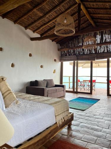 a bedroom with a bed and a couch in a room at Hotel Cariguá in Barichara
