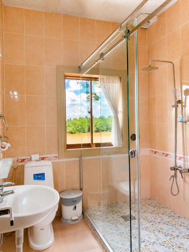 a bathroom with a shower and a toilet and a sink at Hung Vuong Hotel in Ben Tre