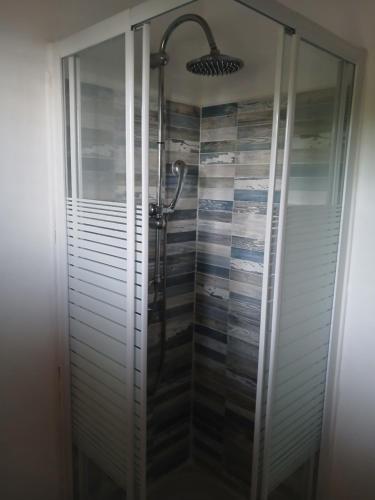 a shower with a glass door in a bathroom at maison du phare in Vieux-Fort