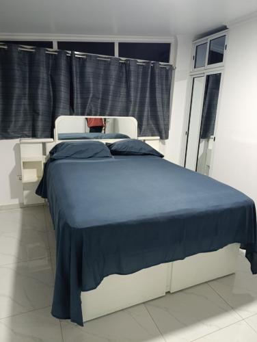a bedroom with a bed with a blue blanket at Apartamento Cidadela in Praia