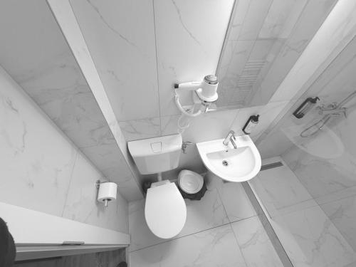 a white bathroom with a toilet and a sink at motel cryss in Ocna Sibiului