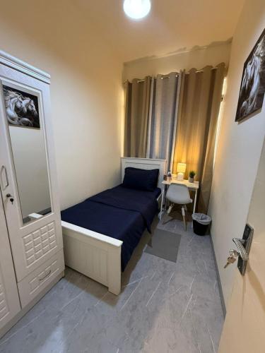 a small bedroom with a bed and a desk at Haven Hub in Abu Dhabi