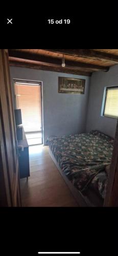 a bedroom with a bed and a desk and a window at Chill & Woods in Štrucljevo
