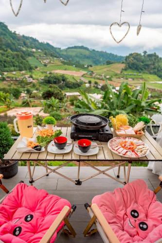 a table with a grill and chairs with food on it at เดอะซัน แกลมปิ้ง in Ban Mae Na