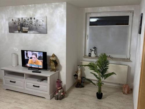 a living room with a tv on a white dresser at Wellness -Residenz Ehrhardt Urlaub mit Pool und Garten Ferienwohnung im Herzen von Halberstadt in Halberstadt