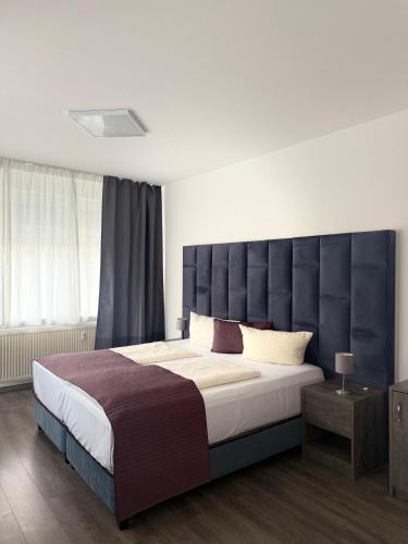 ein Schlafzimmer mit einem großen Bett mit großem Kopfteil in der Unterkunft Wincent Hotel GmbH in Sinsheim