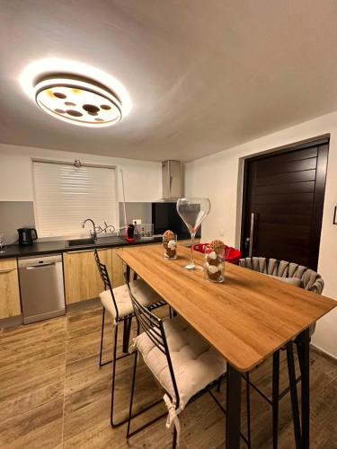 a kitchen with a wooden table with two chairs at Le Clos de Bourgueil in Sainte-Anne
