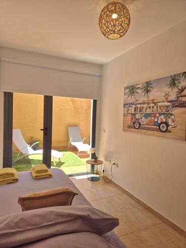 a bedroom with a bed and a painting of a car at Casa en Cotillo Lagos with Free Wifi & Netflix in El Cotillo