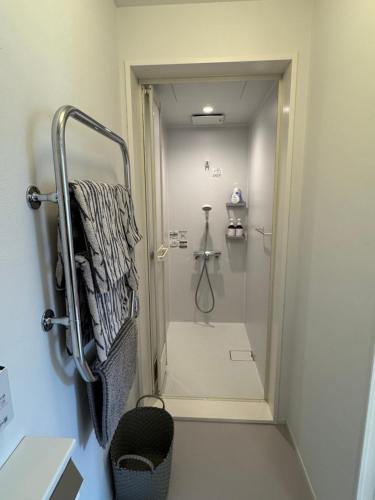 a bathroom with a walk in shower and a shower at Cafe & Stay Flyway in Ogata