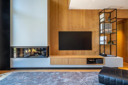 a living room with a television and a fireplace at Isard Penthouse & Spa in El Tarter